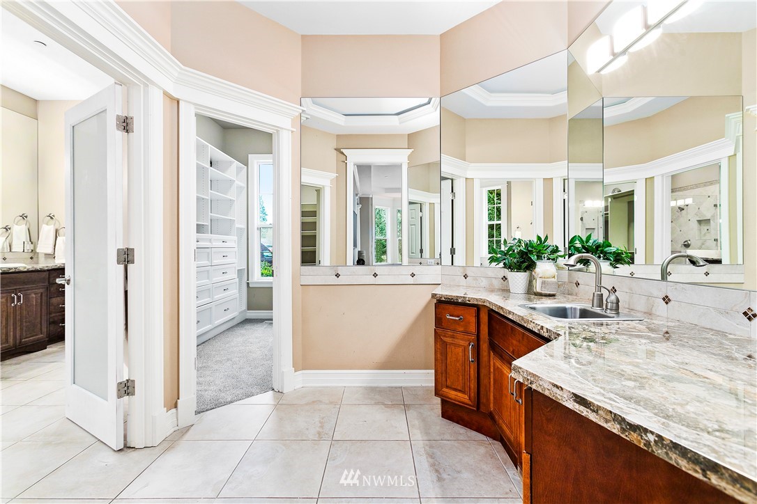 20630 Southeast 216th Street Maple Valley, WA 98038 - Photo 24 of 40 a large bathroom with a granite countertop sink a mirror and a bathtub