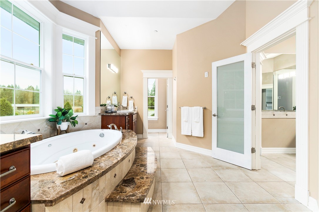20630 Southeast 216th Street Maple Valley, WA 98038 - Photo 26 of 40 a large white tub sitting in a bathroom next to a window