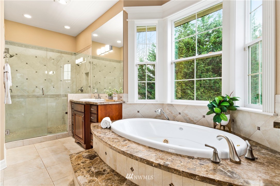 20630 Southeast 216th Street Maple Valley, WA 98038 - Photo 27 of 40 a spacious bathroom with a tub a potted plant and a shower