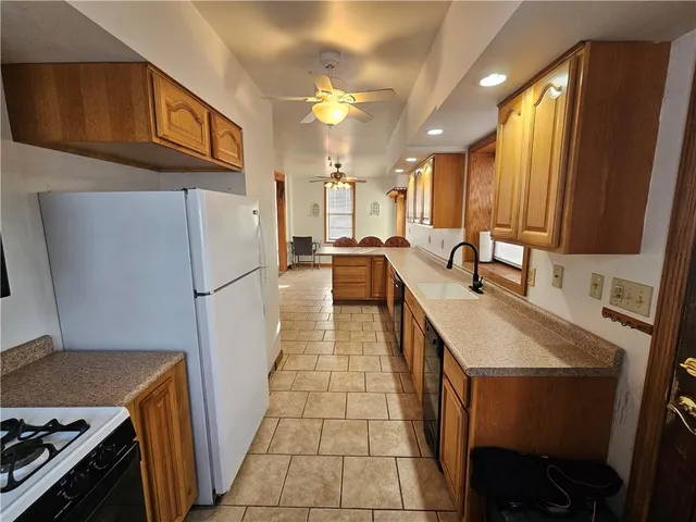 a kitchen with granite countertop a sink stove and refrigerator