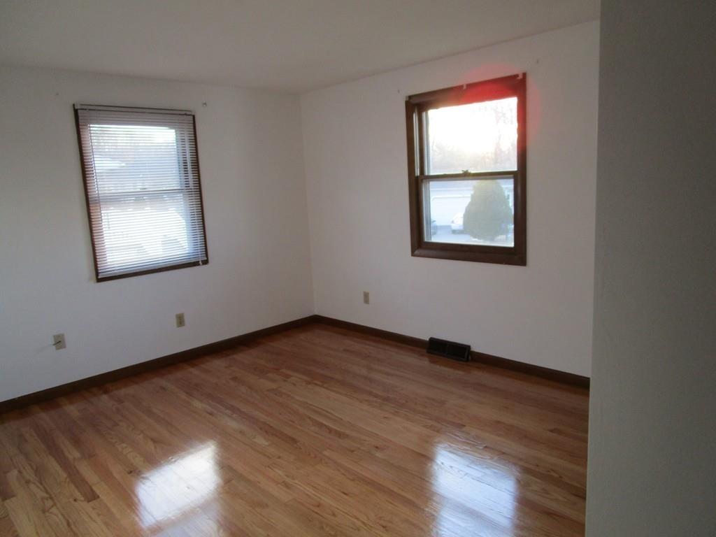 103 Garnet Street Springfield, MA 01129 - Photo 11 of 16 an empty room with wooden floor and windows