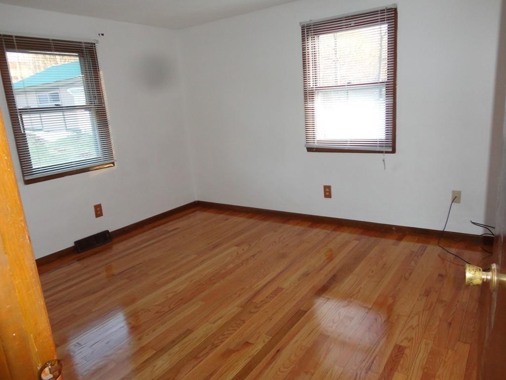 103 Garnet Street Springfield, MA 01129 - Photo 14 of 16 an empty room with wooden floor and windows