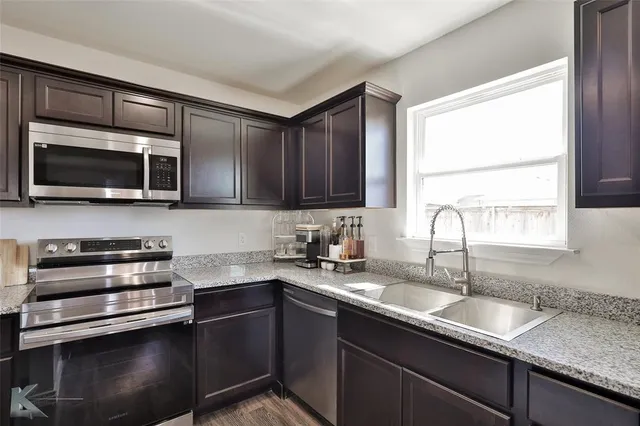 a kitchen with a sink and steel appliances