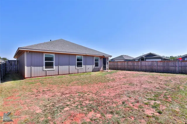 a view of a backyard with wooden fence