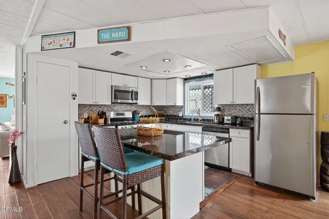 a living room with granite countertop furniture and a wooden floor