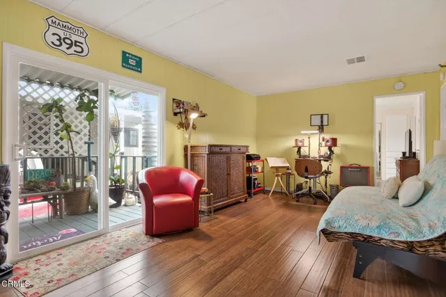 a living room with stainless steel appliances furniture and a kitchen view