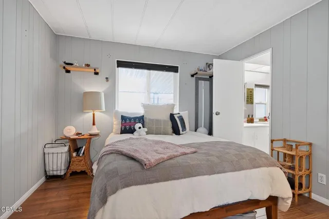 a bedroom with a bed and a mirror on dresser