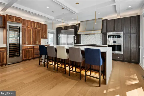 a kitchen with stainless steel appliances kitchen island granite countertop a table chairs and a refrigerator