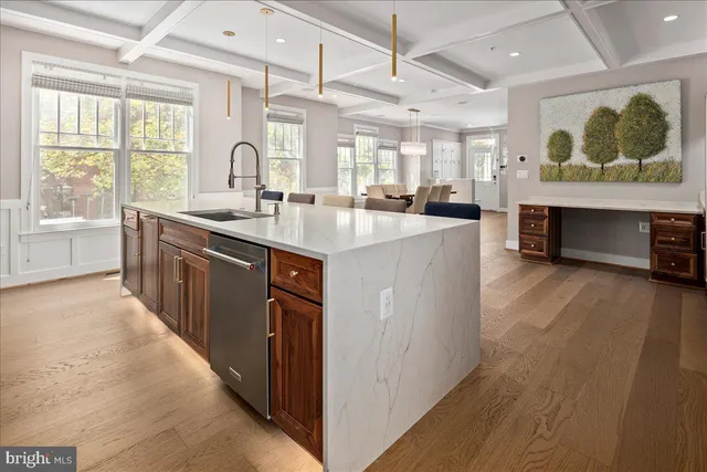 a large kitchen with stainless steel appliances granite countertop a lot of counter space and wooden floor
