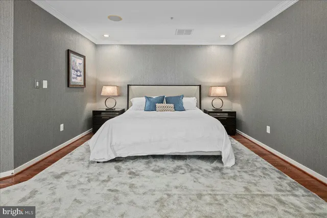 a bedroom with a bed and painting on the wall