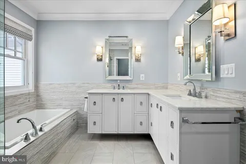 a spacious bathroom with a granite countertop sink mirror and bathtub