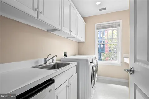 a kitchen with stainless steel appliances a sink a refrigerator and a window