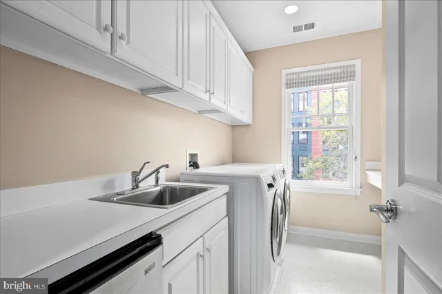 a kitchen with stainless steel appliances a sink a refrigerator and a window