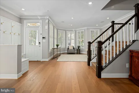 a view of a hallway with wooden floor and stairs