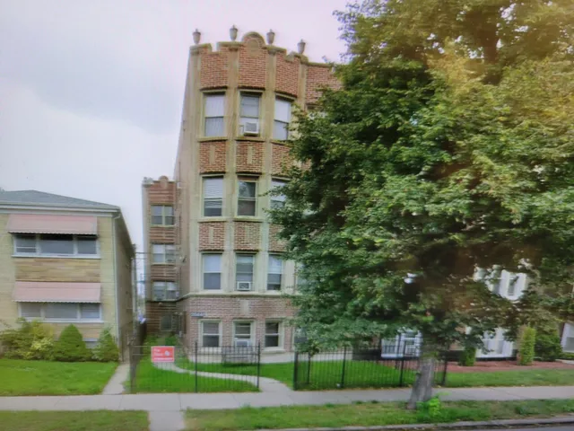 a view of a tall building next to a yard