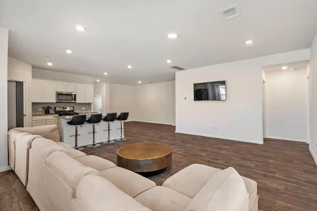 a living room with furniture and view of kitchen