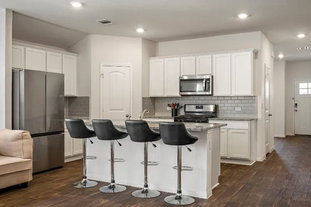 a kitchen with stainless steel appliances a refrigerator stove and microwave