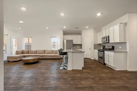 a living room with kitchen island furniture and a kitchen view