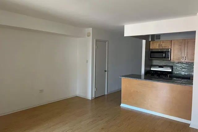 a kitchen with granite countertop a refrigerator and a stove top oven