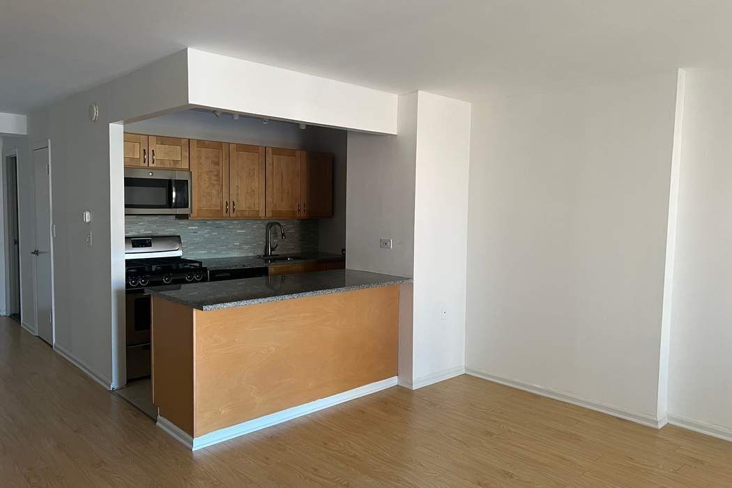 222 West 14th Street, Unit 6H Manhattan, NY 10011 - Photo 3 of 14 a kitchen with stainless steel appliances a sink and a microwave
