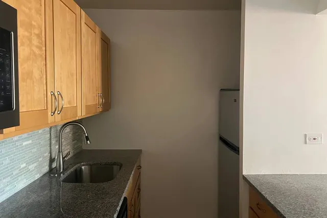 a kitchen with granite countertop a stove sink and cabinets