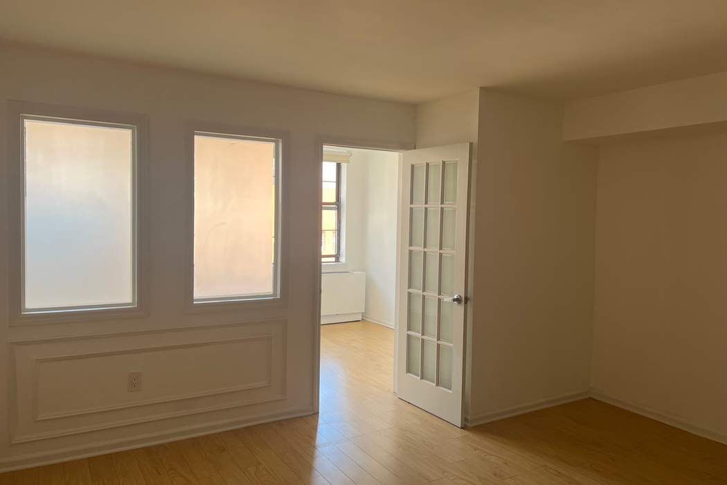 222 West 14th Street, Unit 6H Manhattan, NY 10011 - Photo 7 of 14 an empty room with wooden floor and windows