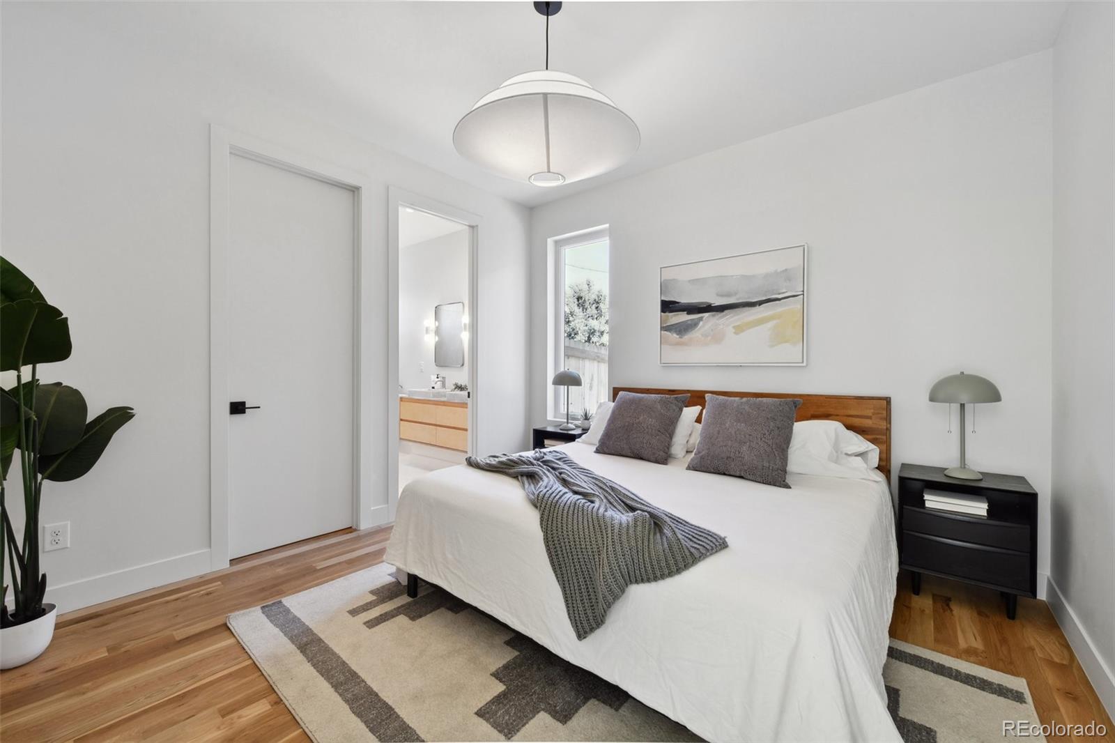 3892 North Cook Street Denver, CO 80205 - Photo 12 of 12 a bedroom with a bed and wooden floor