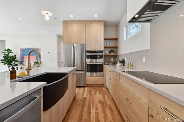 a large kitchen with stainless steel appliances granite countertop a sink and cabinets