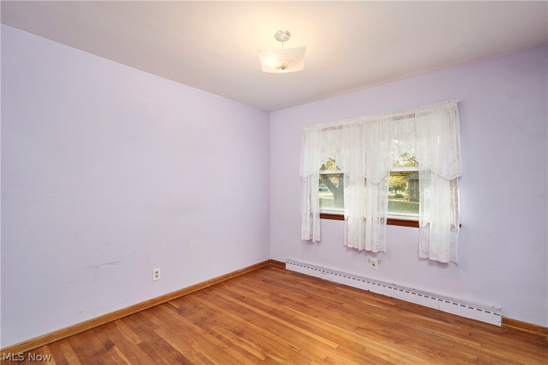 2941 Sweitzer Road Uniontown, OH 44685 - Photo 11 of 16 Unfurnished room featuring baseboard heating and light wood-style floors