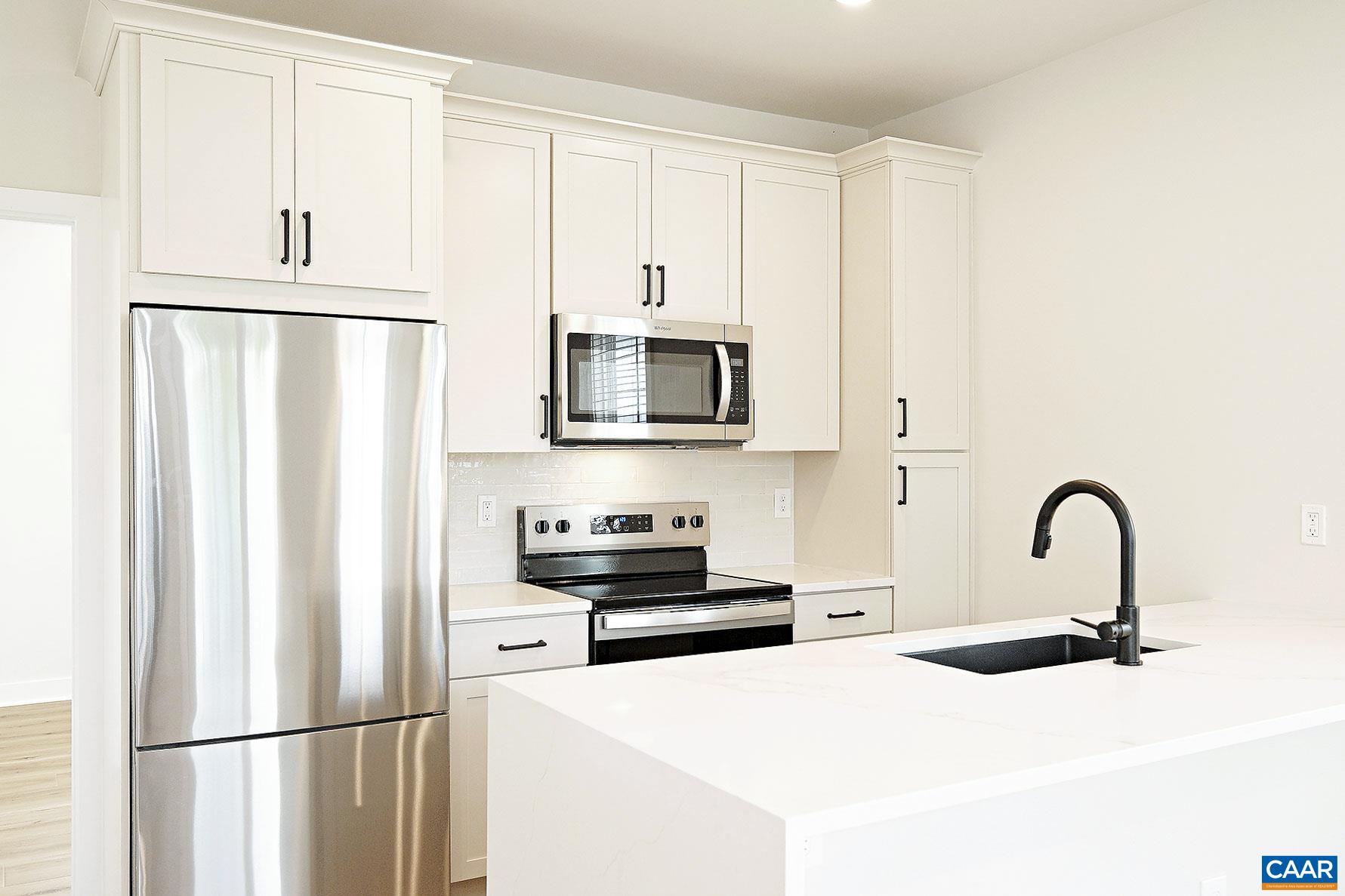 917 Belmont Avenue, Unit A Charlottesville, VA 22902 - Photo 2 of 11 a kitchen with stainless steel appliances a refrigerator sink and white cabinets