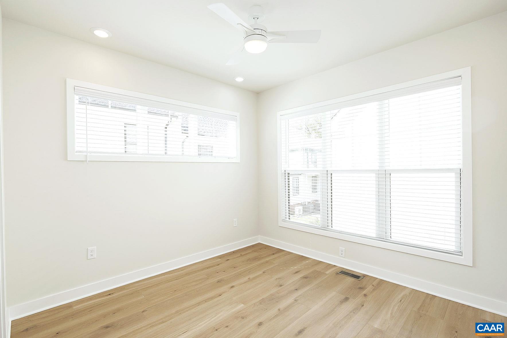 917 Belmont Avenue, Unit A Charlottesville, VA 22902 - Photo 6 of 11 an empty room with wooden floor and windows