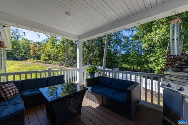 a living room with stainless steel appliances furniture a dining table and chairs