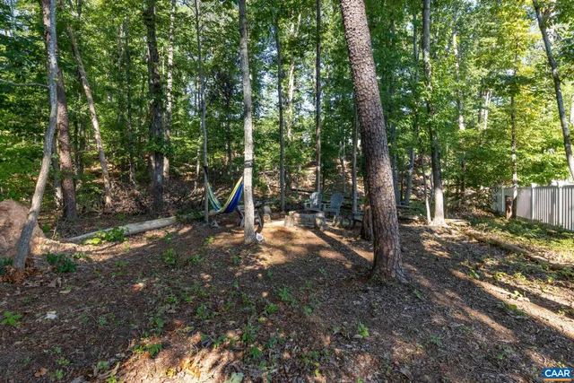 a view of a patio with table and chairs potted plants and large tree