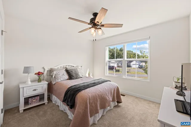 a bedroom with a large bed and a flat tv screen on dresser