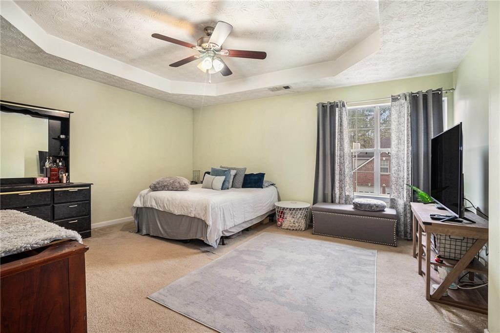 1777 Cutters Mill Way Lithonia, GA 30058 - Photo 12 of 23 a spacious bedroom with a bed and a flat screen tv