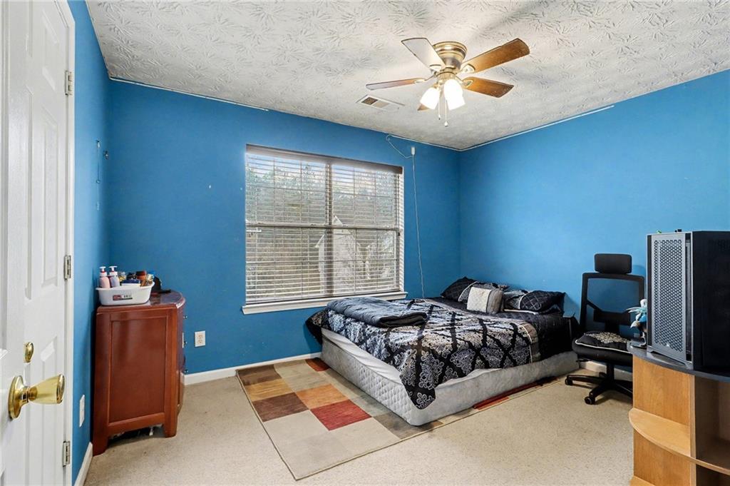 1777 Cutters Mill Way Lithonia, GA 30058 - Photo 20 of 23 a spacious bedroom with a bed and a chandelier