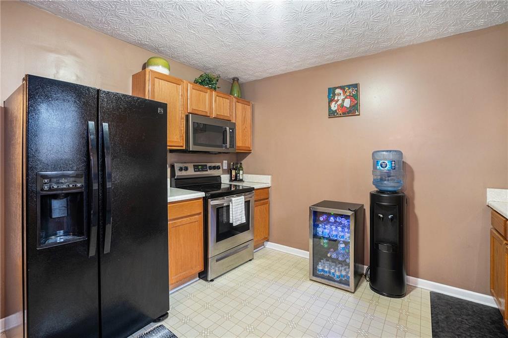 1777 Cutters Mill Way Lithonia, GA 30058 - Photo 8 of 23 a kitchen with stainless steel appliances granite countertop a refrigerator and a stove