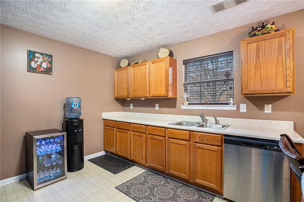 1777 Cutters Mill Way Lithonia, GA 30058 - Photo 10 of 23 a kitchen with stainless steel appliances granite countertop a sink dishwasher a refrigerator and cabinets with wooden floor