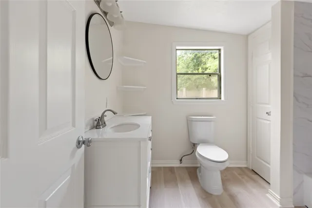 a bathroom with a toilet sink and mirror