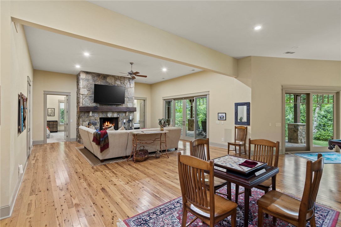 117 Sunrise Ridge Sunset, SC 29685 - Photo 28 of 44 A spacious living area features hardwood floors, a striking stone fireplace, and abundant natural light from large glass doors.
