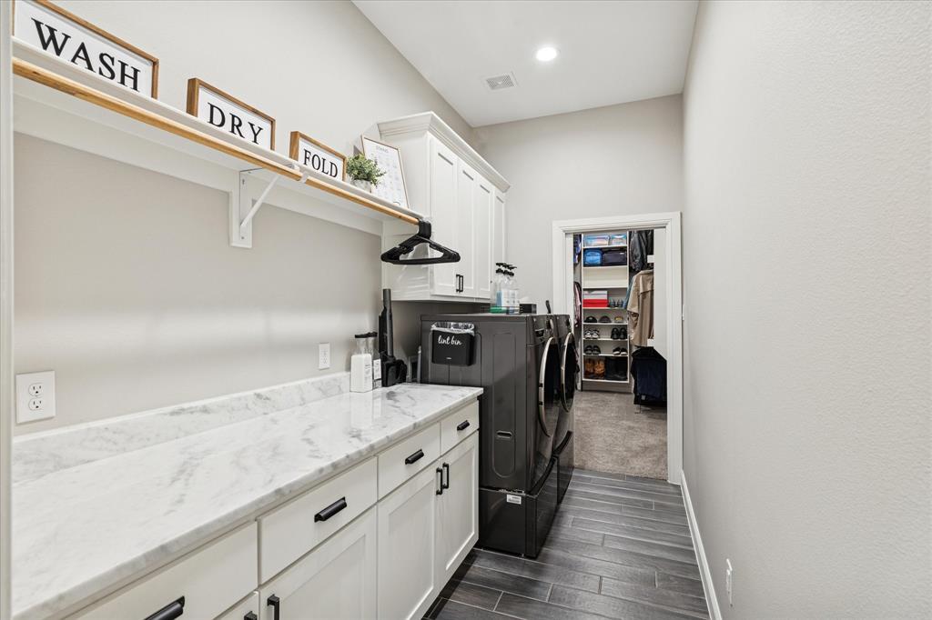 112 Friendship Way Boyd, TX 76023 - Photo 23 of 29 Dedicated laundry space featuring a white countertop with subtle veining, ample white cabinetry, and slate-finish flooring