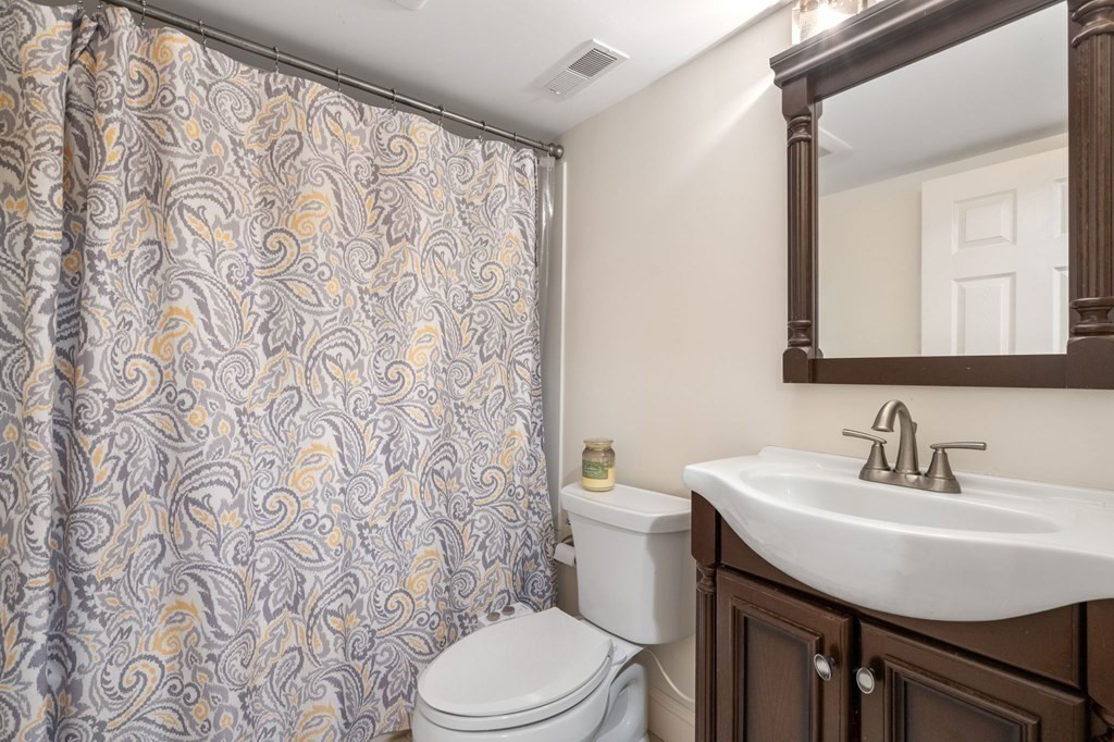 28 Rose Avenue, Unit 28 Watertown, MA 02472 - Photo 17 of 25 a bathroom with a toilet a sink and a mirror