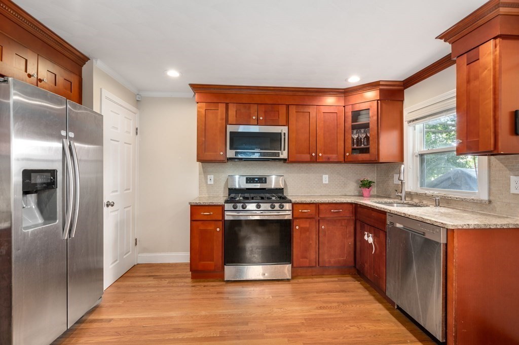 28 Rose Avenue, Unit 28 Watertown, MA 02472 - Photo 21 of 25 a kitchen with stainless steel appliances granite countertop a stove a sink and a refrigerator