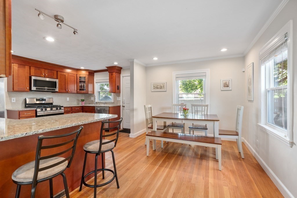 28 Rose Avenue, Unit 28 Watertown, MA 02472 - Photo 4 of 25 a kitchen with stainless steel appliances a stove a sink dishwasher and a refrigerator with wooden floor