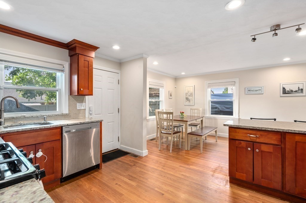 28 Rose Avenue, Unit 28 Watertown, MA 02472 - Photo 6 of 25 a view of a kitchen with kitchen island granite countertop wooden floors and a view of living room