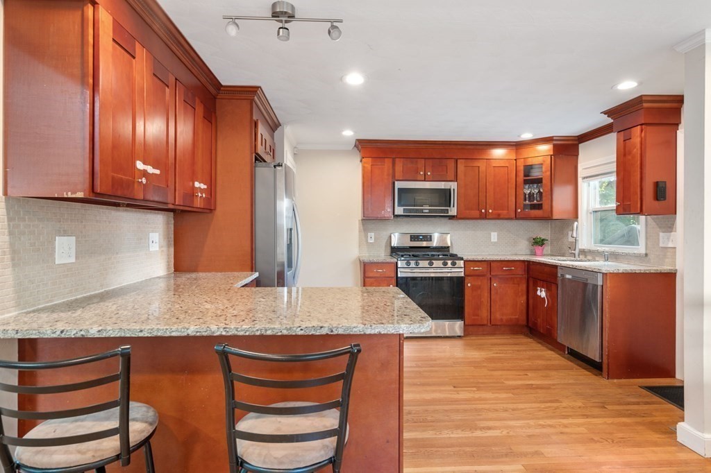 28 Rose Avenue, Unit 28 Watertown, MA 02472 - Photo 8 of 25 a kitchen with stainless steel appliances granite countertop a stove a sink and a microwave