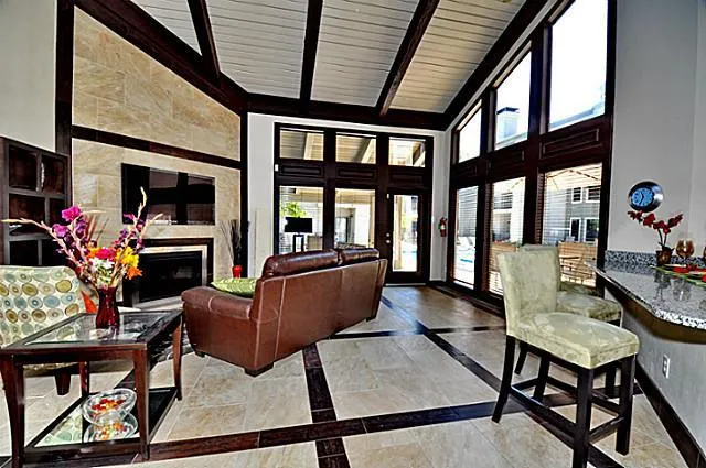 a living room with furniture a flat screen tv and a floor to ceiling window