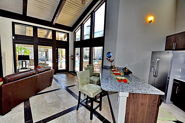 6910 Skillman Street, Unit 1007 Dallas, TX 75231 - Photo 19 of 24 a view of a dining room with furniture a chandelier and wooden floor