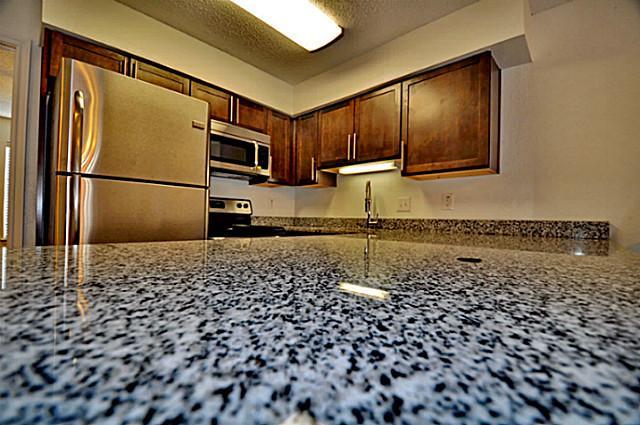 6910 Skillman Street, Unit 1007 Dallas, TX 75231 - Photo 4 of 24 a kitchen with a refrigerator and a sink