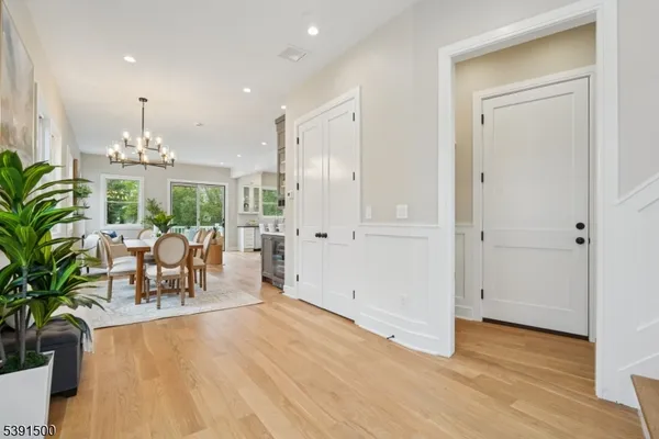 a dining room with furniture a chandelier and wooden floor